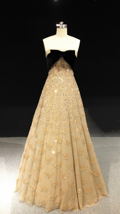Strapless gold gown with crystal scales and a velvet bow